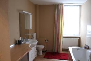 ein Badezimmer mit Waschbecken, Toilette und Fenster in der Unterkunft Wohnstudio auf Schloss Semlow in Semlow
