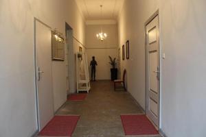 Ein Flur mit Türen und eine Person, die in der Ferne steht in der Unterkunft Wohnstudio auf Schloss Semlow in Semlow