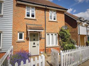 a brick house with a white fence in front of it at Sunnyside in Camber