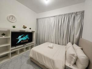 a bedroom with a bed and a tv in it at شقة مصدر in Abu Dhabi