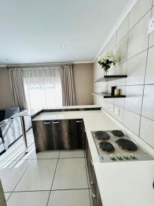 a large white kitchen with a stove top oven at BoniM Guesthouse - aka Magisha Guesthouse in Nelspruit