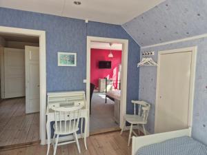 a room with blue walls and a table and chairs at Vitahästen in Hästveda +30 photos