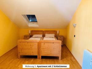 a bedroom with two beds in a room with yellow walls at Schads Bergheimat in Wertach