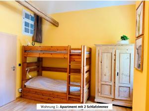 a bunk bed in a room with a yellow wall at Schads Bergheimat in Wertach