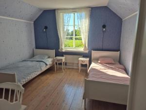 a bedroom with two beds and a window at Vitahästen in Hästveda