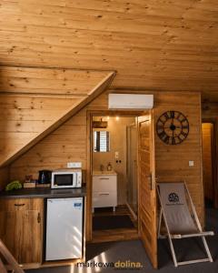 a kitchen in a log cabin with a stove and a microwave at Apartamenty Markowa Dolina in Rymanów +3 photos