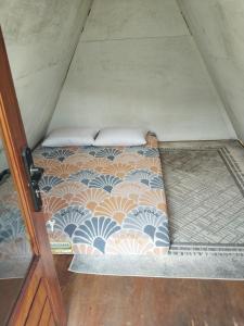 a bed in the middle of a room at Cihulu Budget Glamping in Tengahgirang