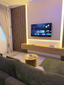 a living room with a couch and a flat screen tv at Was Homes in Abuja