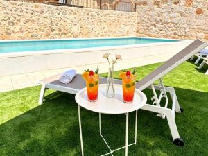 a table with two cocktails on it next to a pool at La Serrería-Premium Suite Apartments & Private Jacuzzi in Belmonte