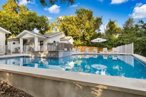 a swimming pool with chairs and a house at The Grove Combo in Fredericksburg