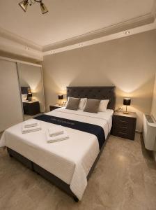 a bedroom with a large bed with two towels on it at Villa Royalstone in Donja Ralja +26 photos