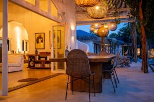 a living room with a wooden table and chairs at Villa Paz - La Villa Group in Camocim