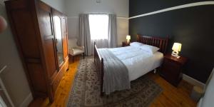 a bedroom with a large bed and a window at Beach Street Self-Catering in Mossel Bay