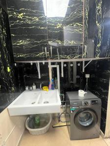a bathroom with a sink and a washing machine at Sahara View Guest House Prime Location on the Dubai Sharjah Border in Sharjah +34 photos
