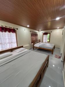 a large bedroom with two beds and a ceiling at Spatika Villa in Madikeri +10 photos