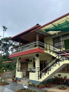 a building with stairs and a bird in front of it at Spatika Villa in Madikeri