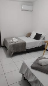 a white room with a bed with towels on it at Pousada dos Marujos in Pipa