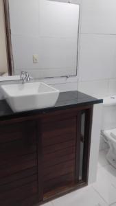 a bathroom with a sink and a mirror at Pousada dos Marujos in Pipa