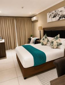 a bedroom with a large bed with a green blanket at BoniM Guesthouse - aka Magisha Guesthouse in Nelspruit +31 photos