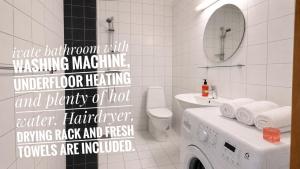 a white bathroom with a washing machine in it at Bergvegen Guesthouse Aalesund in Ålesund