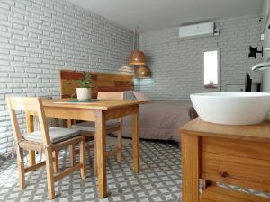 a bathroom with a table and a sink and a bed at Casa Olivia Habitación Privada in Alta Gracia