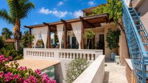 a house with a white fence and flowers at Villa Kallergi Athena in Loutra