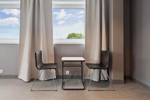 two chairs and a table in front of a window at Måby Park Hotel Arlanda in Arlanda