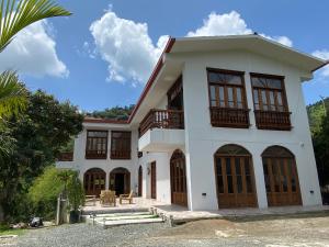 a large white house with a lot of windows at Casa Colonial Maria Elena in Pereira