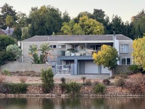 an image of a house next to a body of water at BelleVue Cottage in Durbanville