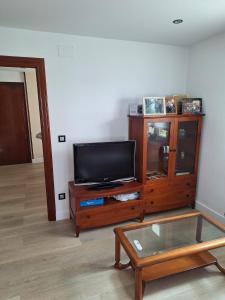 a living room with a tv and a wooden entertainment center at Casa de la güela in Avilés