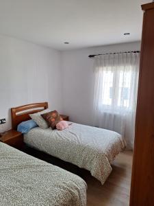 a bedroom with two beds and a window at Casa de la güela in Avilés