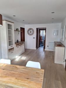 a kitchen with a table and chairs and a clock on the wall at Casa de la güela in Avilés +4 photos