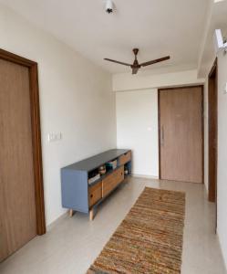 a living room with a cabinet and a rug at Lodha Crown Premium 2BHK Thane in Thane