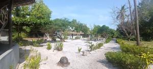 a path in the sand with trees and a house at MafiaSeaview in Kilindoni