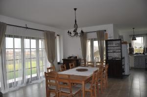 y cocina con mesa de comedor y sillas y ventanas. en Villa De Dominique, en Erdőbénye