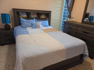 a bedroom with a large bed with blue pillows at La Abuela Hospitality in Dorado