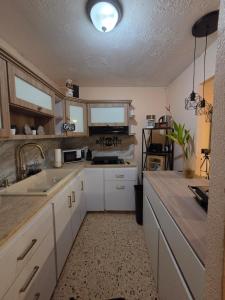 a kitchen with white cabinets and a sink at La Abuela Hospitality in Dorado