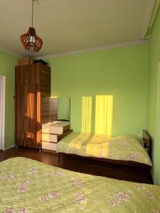 a bedroom with two beds and a dresser at Light in August in Kobuleti