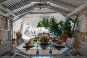 a dining room with a table with fruits and wine glasses at Villa Kallergi Nefeli in Loutra