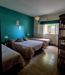 a bedroom with two beds and a green wall at Descanso de Caroya in Colonia Caroya