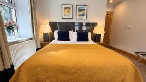 a bedroom with a large yellow bed with two lamps at Crystal House in Barmouth