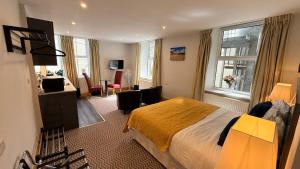 a hotel room with a large bed and a desk at Crystal House in Barmouth