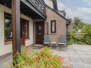 a patio with two chairs and a table in front of a building at Ty Haf in Holyhead