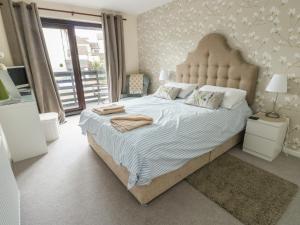 a bedroom with a large bed with a large headboard at Ty Haf in Holyhead