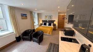 a hotel room with a bed and two chairs at Crystal House in Barmouth +80 photos