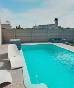 a swimming pool with a white chair at The Thrush in Cañuelas