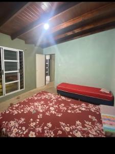 a bedroom with a red bed with a red blanket at The Thrush in Cañuelas