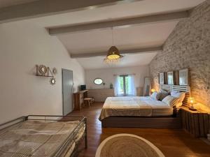 a bedroom with a large bed and a stone wall at Logis de Rault in Sainte-Ouenne +46 photos