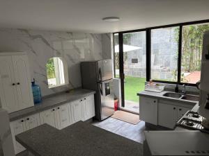 a kitchen with white cabinets and a large window at Casa Bamboo in Mexico City