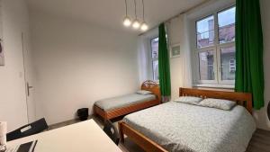 a room with two beds and a desk and windows at Rynek 5 in Poznań